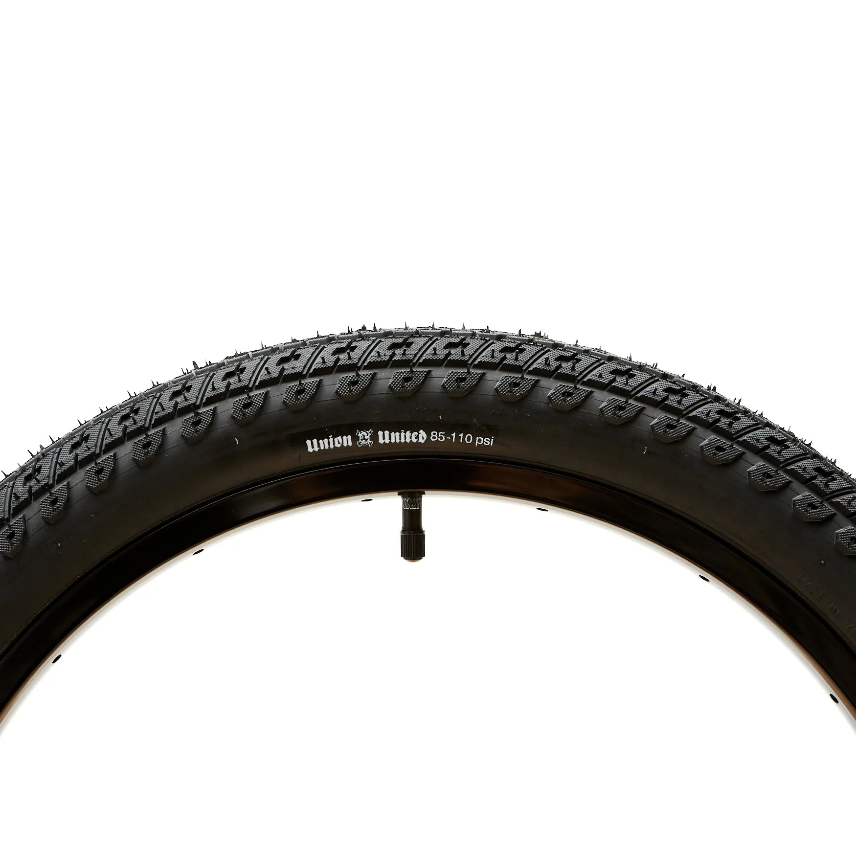 Image of a black bicycle tire with tread, mounted on a rim. The tire, featuring an aggressive directional dirt profile, is labeled "United Indirect Tyre 85-110 psi." This product showcases the Bicycle Union collaboration at its finest.