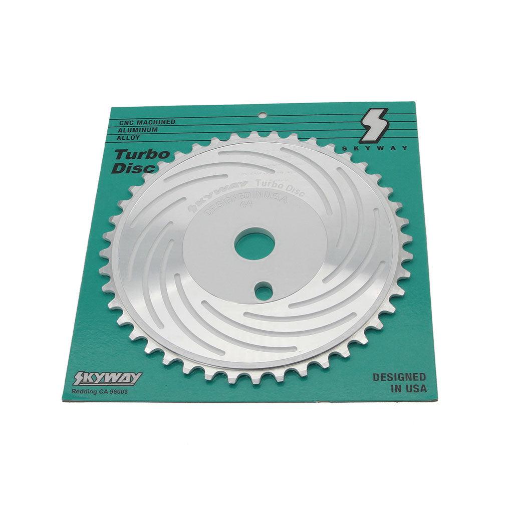 Image shows a Skyway Turbo Disc Front Sprocket attached to its green and white packaging. The chainring is made from CNC machined 6061 aluminum alloy. Text on the packaging indicates it is designed in the USA.