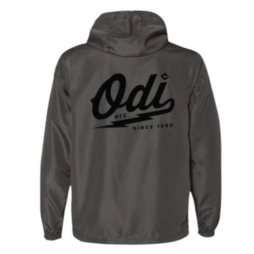 The ODI Heater Windbreaker is a gray hooded jacket with "Odi MFG. Since 1980" in black script on the back, designed to keep you comfortable in breezy conditions.