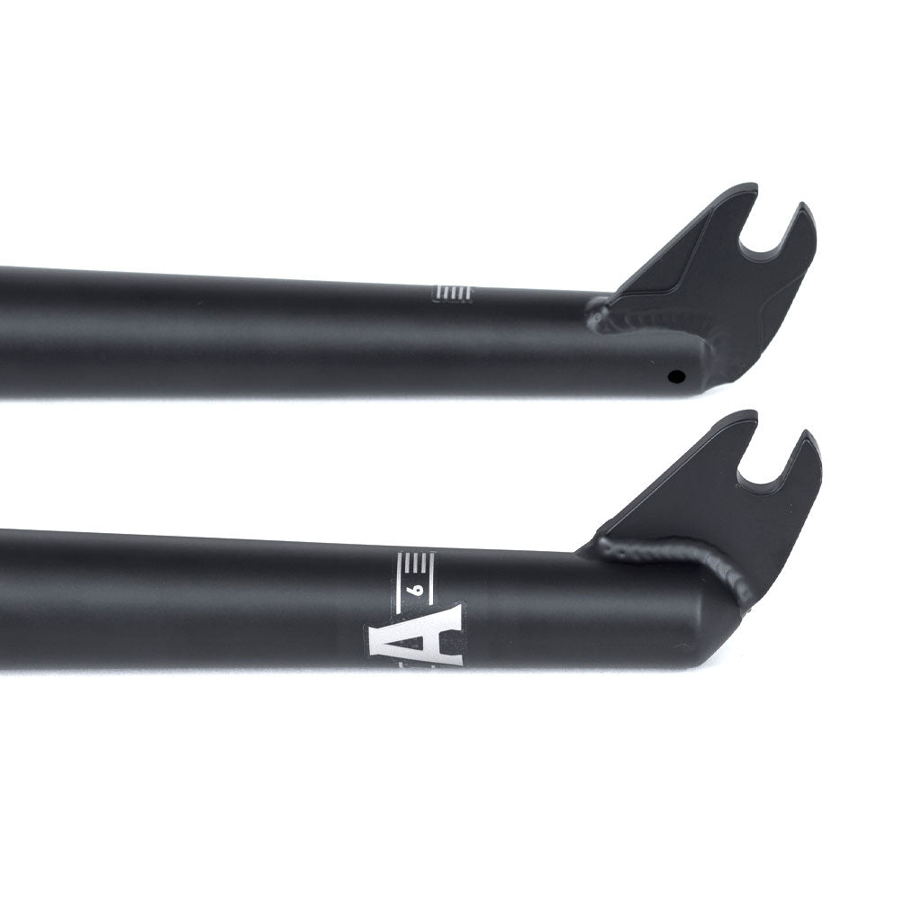 Two black Wethepeople Audio 22 Inch Forks with sleek matte finish and white graphic details, featuring CNC dropout detail for precision and integrated crown race.