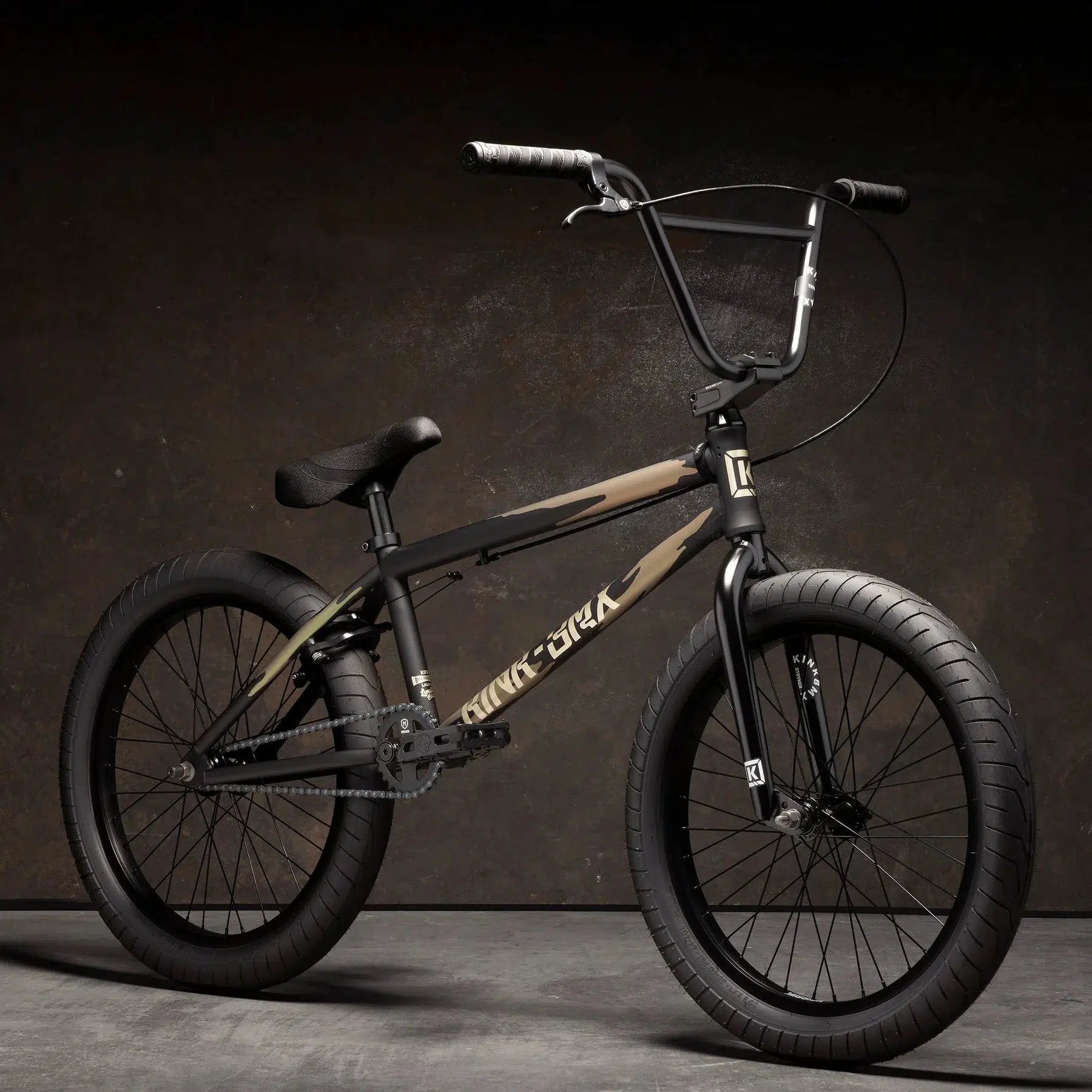 The Kink Launch 20 Inch Bike, a black BMX with thick tires and a sturdy frame, stands boldly against the dark background.