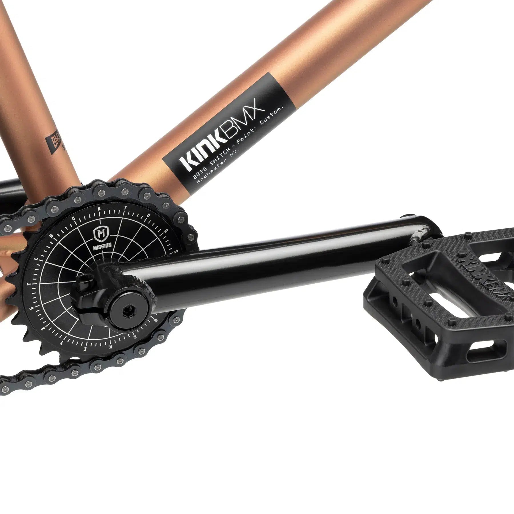 Close-up of a BMX bike crankset and pedal, showcasing a gold frame reminiscent of the Kink Switch 20 Inch Bike, with a black chainring and pedal attached.