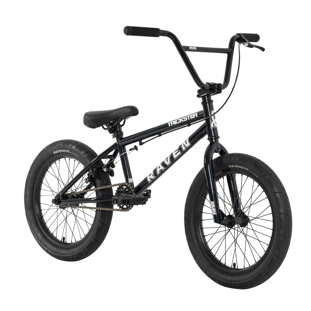 The Raven Trickster 18 Inch Bike is an ideal choice for beginner riders, featuring a black BMX design with thick tires, a padded seat, and a chain drive. It comes equipped with sealed bearing hubs and showcases brand logos on both the frame and tires for enhanced style and performance.