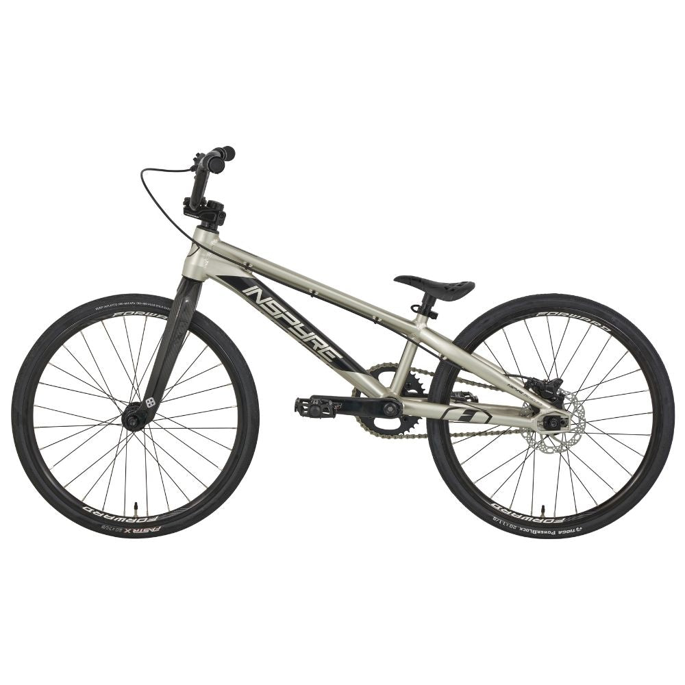 The Inspyre Evo-C Disc Junior Bike 2025 boasts a sleek silver design with black handlebars and tires, perfect for BMX racing. The brand name is prominently displayed on the frame, promising high performance.