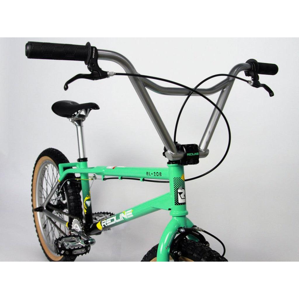 A striking design reminiscent of the Redline RL20B Retro 20 Inch Bike showcases large handlebars, black grips, and tan tires against a plain background. This green gem embodies the classic BMX style.