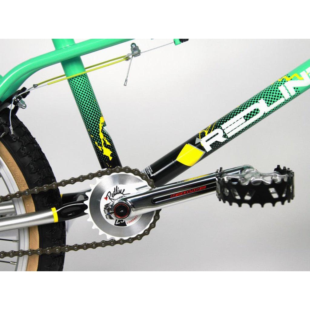 A close-up of the bike's midsection reveals a green frame, chain, pedal, and tire. The brand name "Redline RL20B Retro 20 Inch Bike" is prominently displayed on the frame, showcasing its BMX design.