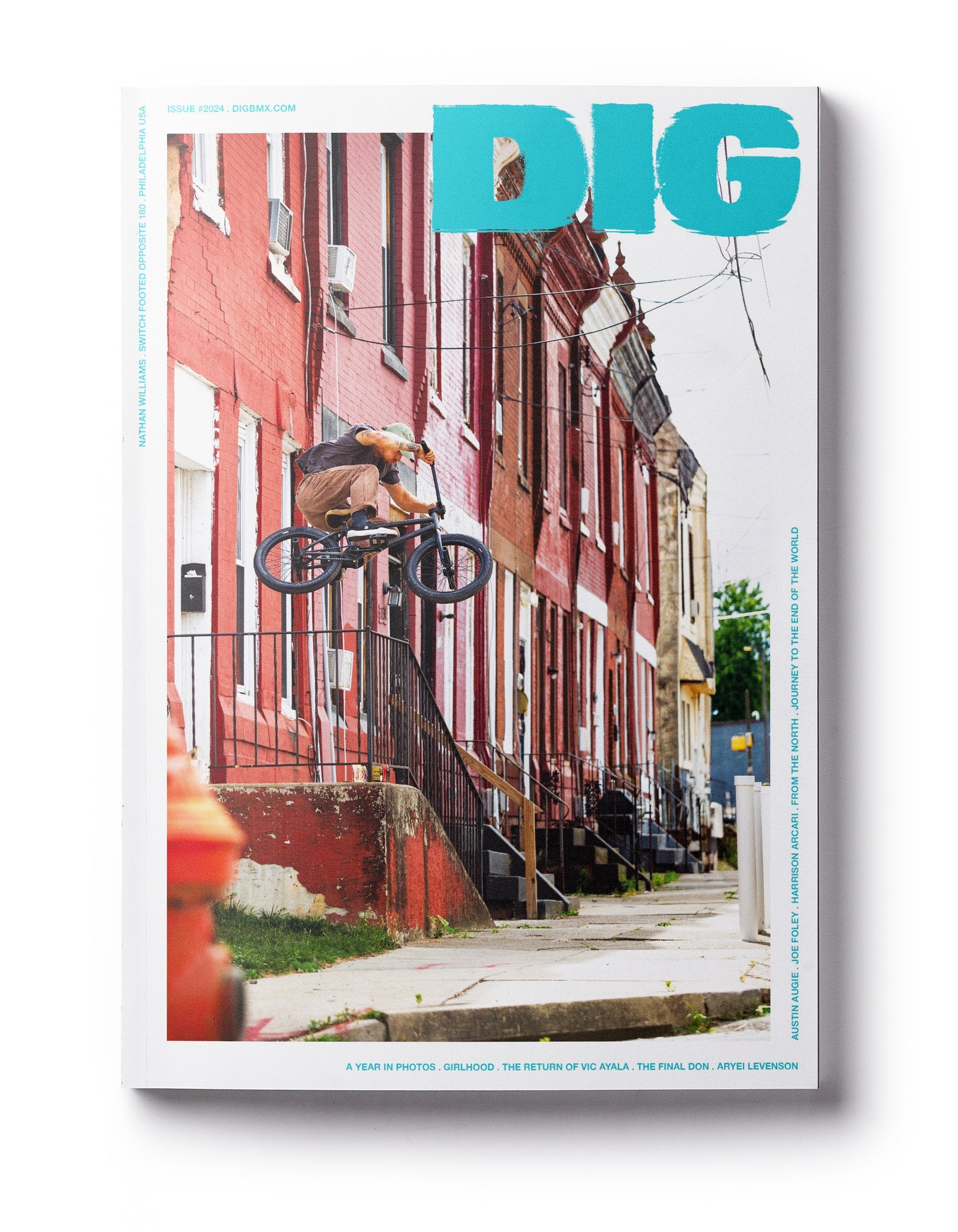 Magazine cover of DIG Book 2024 - Photo Annual showcases a cyclist jumping on a bicycle in front of red brick buildings.