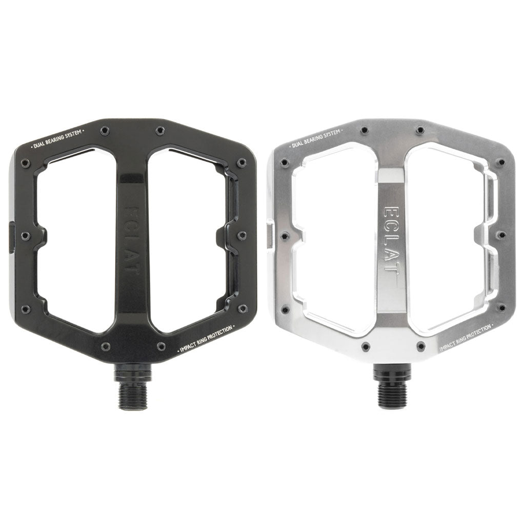 Two bicycle pedals, one in black and one in silver, both featuring the brand name "Eclat" and a rectangular shape with cut-out designs for lightweight performance. The Eclat Surge XL Pedal also boasts an oversize platform area and a dual bearing/bushing spindle system for enhanced durability.