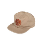 A beige cotton BSD Psyched Out Cap with a curved visor and an orange graphic design on the front, featuring an adjustable fastener for the perfect fit.