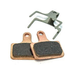 Close-up of a pair of Clarks VX Organic Disc Brake pads with a metal clip on a white background. The brake pads feature rectangular friction material, ensuring enhanced braking power and reduced noise.