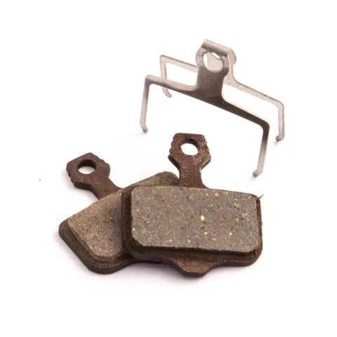 The Clarks VX Organic Disc Brake pads, accompanied by a metal clip, are displayed on a plain white background, providing enhanced braking power and reduced noise.