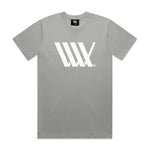 The LUXBMX Flag Tee Storm is a grey, heavyweight t-shirt made from soft combed cotton. It features a large white "W" logo on the chest and a small black tag at the neckline, offering both comfort and style.