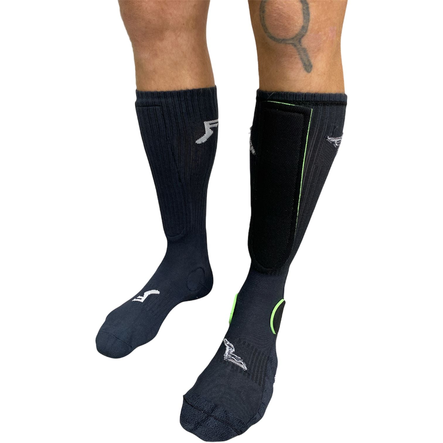 Person's legs wearing FP Painkiller Socks Crew Cut crafted from mildew-resistant bamboo fabric; the right sock includes a black shin guard.