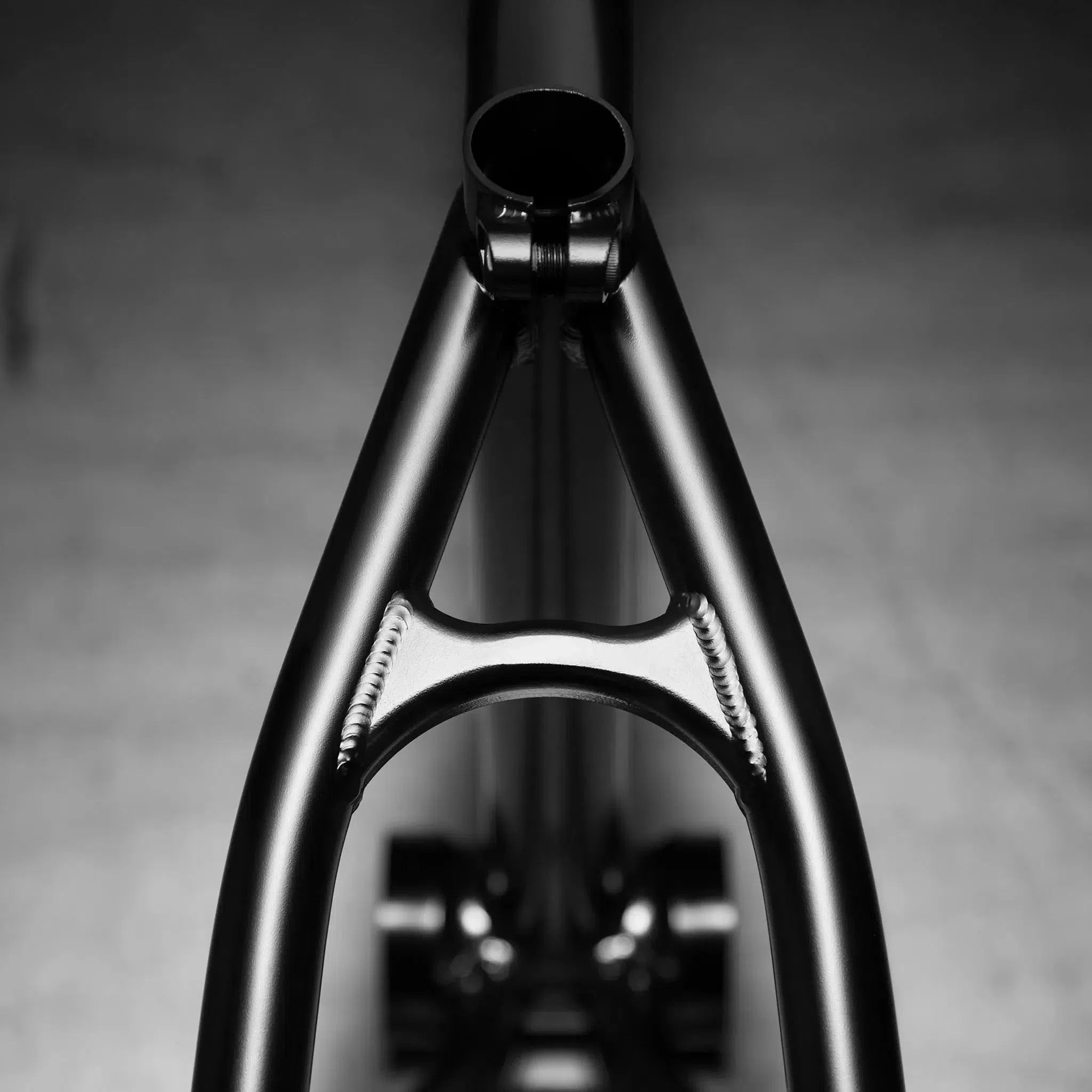 Close-up of the Kink Tactic Frame, a black bicycle frame crafted from durable chromoly tubing with visible welds, highlighting its street frame design against a neutral backdrop.