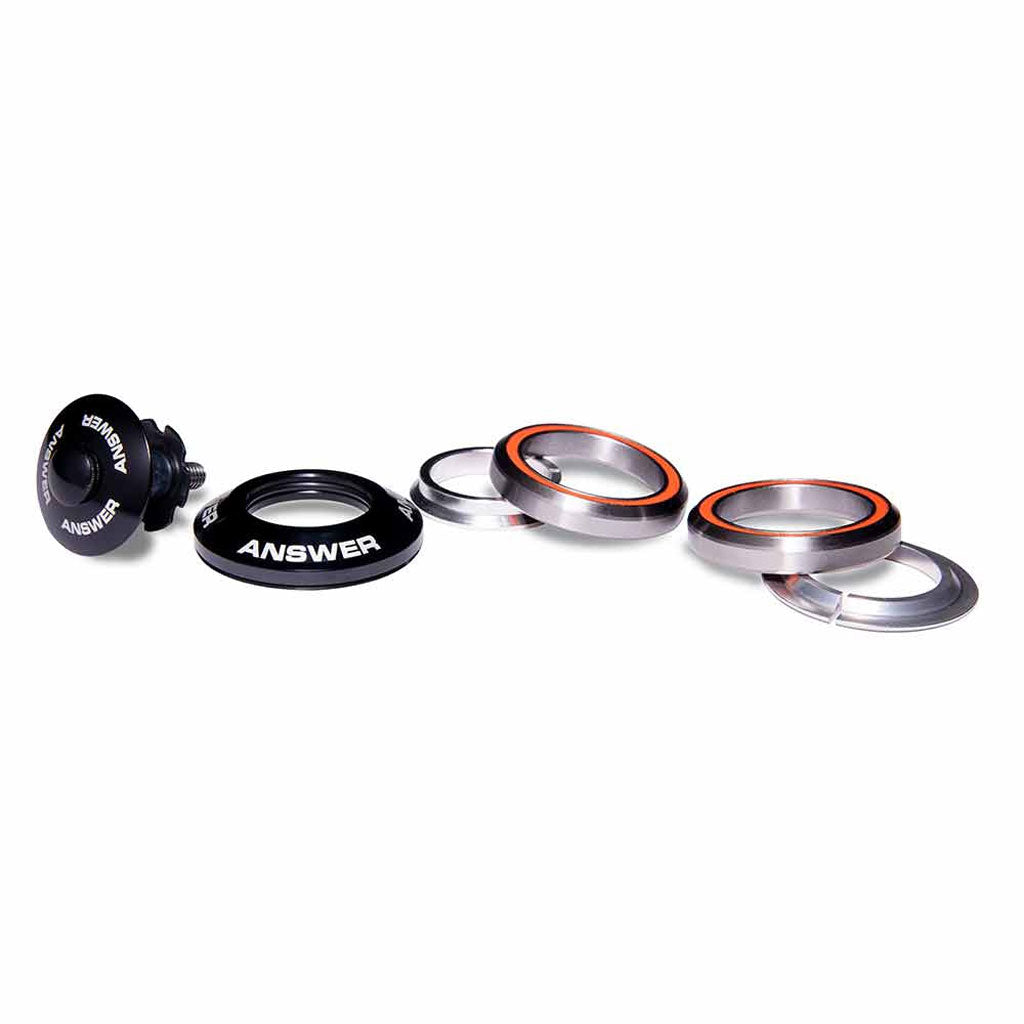 The Answer 1-1/8 to 1″ Integrated Headset Reducer is displayed on a white background, featuring components like bearings, spacers, and a top cap labeled "ANSWER." This set is designed for easy integration with 1-inch forks, making it perfect for 1-1/8 inch frames with step-down headset capability.