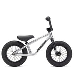 The Kink Coast Balance Bike, in a silver finish, boasts sleek black handlebars and tires that beautifully contrast with its clean white accents.