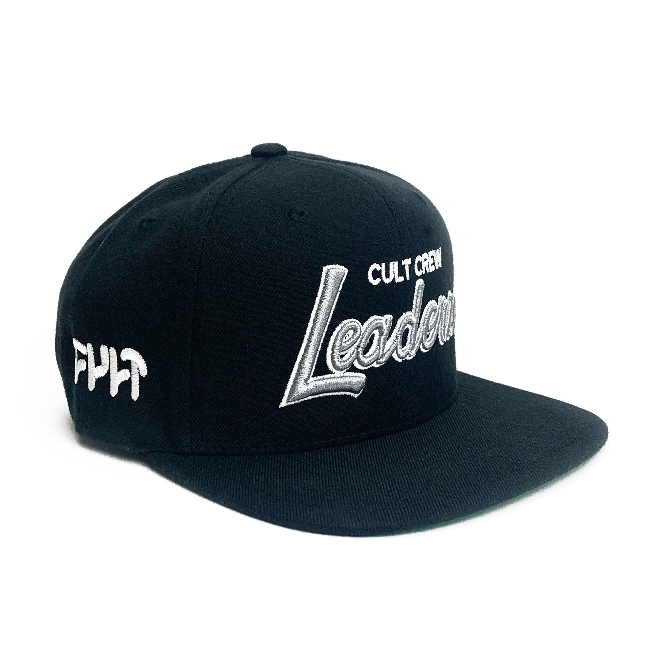 Product Description: The Cult Leaders Snapback Cap is a black snapback baseball cap, expertly crafted from a premium wool blend. It prominently features the word "Leaders" in striking 3D white embroidery on the front, with "CULT CREW" displayed above it. The side of the cap is adorned with "FMLT.