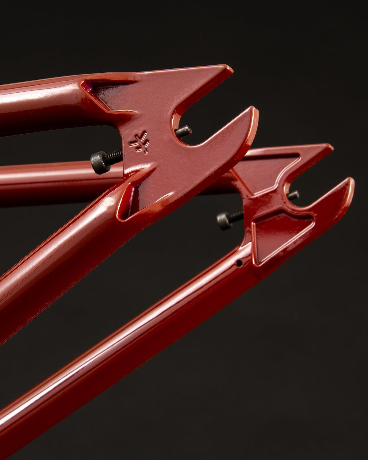 Close-up of a Fly Bikes Sierra Frame dropout on a black background, highlighting the 4130 CrMo steel rear fork ends with bolt holes.