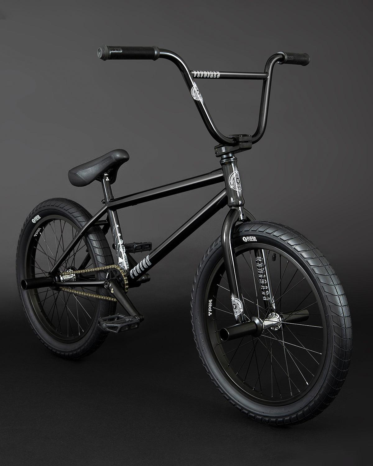 The Fly Bikes Proton FC 20 Inch Bike showcases a CrMo frame with thick tires and straight handlebars, designed for smooth rides with its sealed hubs, all set against a dark background.