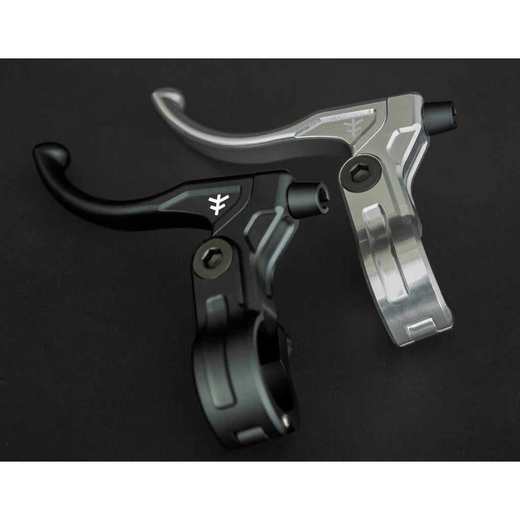 The Fly Bikes Manual CNC Brake Lever, made from 6061-T6 Aluminum in black and silver, stands out against a dark background.