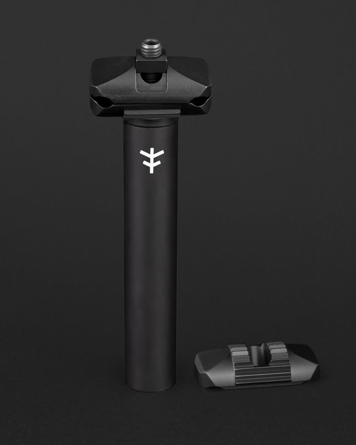 The Fly Bikes Motosierra Railed Seat Post is a sleek black cylindrical post made of CNC machined 6061-T6 aluminum, featuring a logo and an accompanying bracket. Ideal for those who value durability and precision in a ripper seat post.