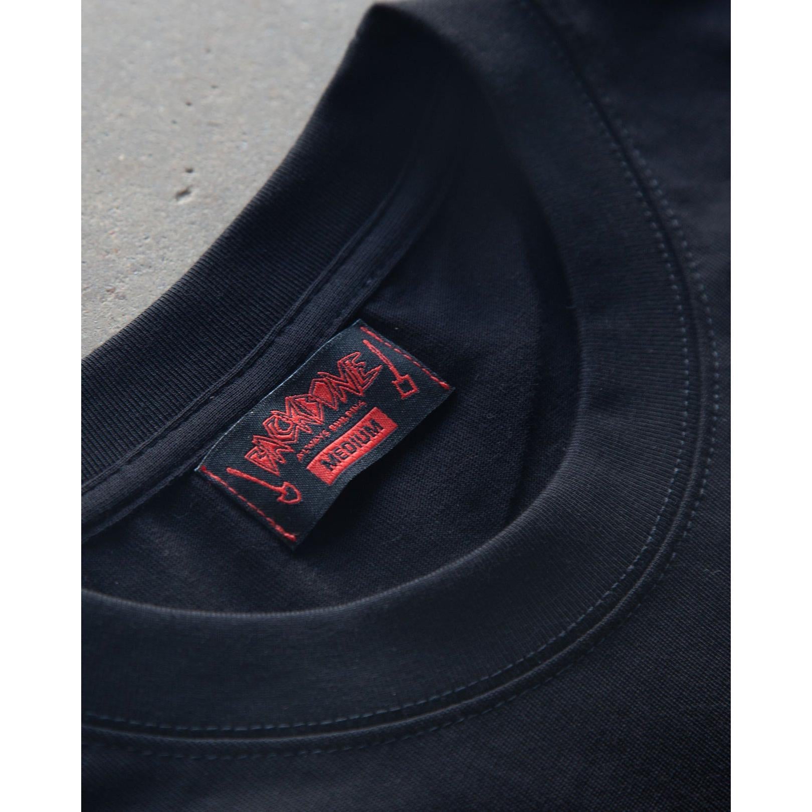 Close-up of a Backbone No Weak Links T-Shirt in black featuring a red and black neck tag with the brand name and size "Medium." Made from heavyweight cotton for a comfortable boxy fit, ideal for casual occasions.