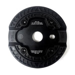 A circular, black mechanical component with four screws, labeled "PRIMO PARTS COMPANY" and "DESIGNED IN LBC, CA." The lightweight durable Primo Omniguard Sprocket features ridged detailing, a central hole, and an optional bolt-on replaceable nylon guard.