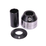 Three Primo Mid Bottom Bracket components in black and silver, including cone spacers, are arranged on a white background.