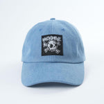 Light blue Backbone Real Deal 6 Panel Hat, low profile, featuring a black patch with a Skull logo on the front.