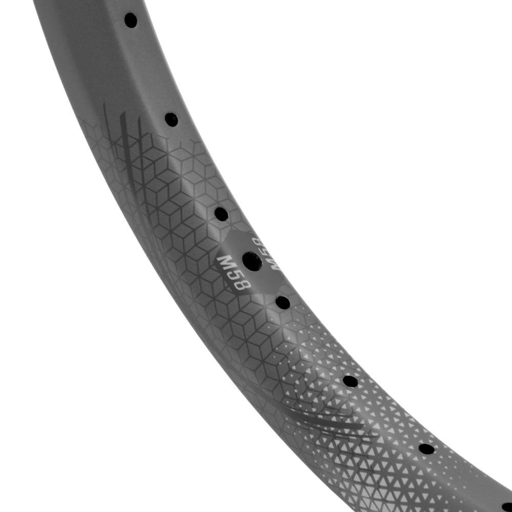 Close-up of a gray bicycle rim labeled "M68," showcasing a geometric pattern and spoke holes. This high-performance rim offers durability akin to the SD-X M58 V2 Carbon Race Rim Brakeless, ensuring an outstanding ride.