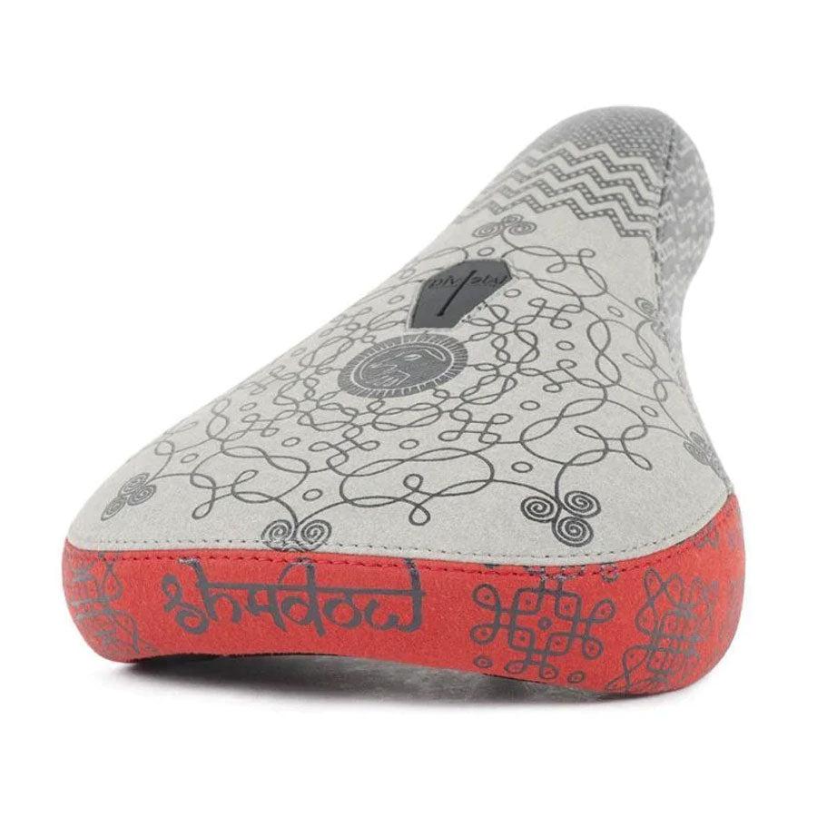 A gray Shadow Penumbra Pivotal Mid Seat, Coulomb seat with intricate, abstract black patterns on the surface and a red underside adorned with Rangoli-inspired symbols and text offers a unique seat for any rider.