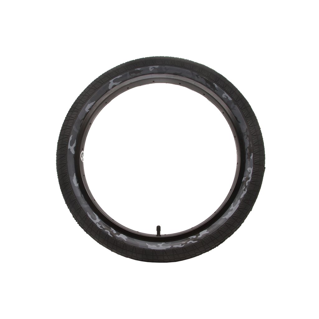 A DRS Vise Camo Tyre with a black exterior and a unique camouflage pattern on the inner surface, optimized for improved traction, is displayed against a simple white backdrop.