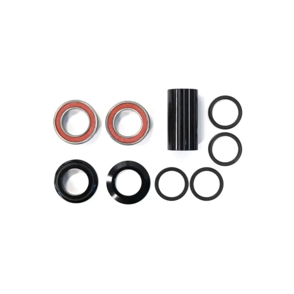 A Defiant Spanish Bottom Bracket consisting of four metal bearings, two cylindrical spacers, and six rubber O-rings arranged in an organized manner on a white background.