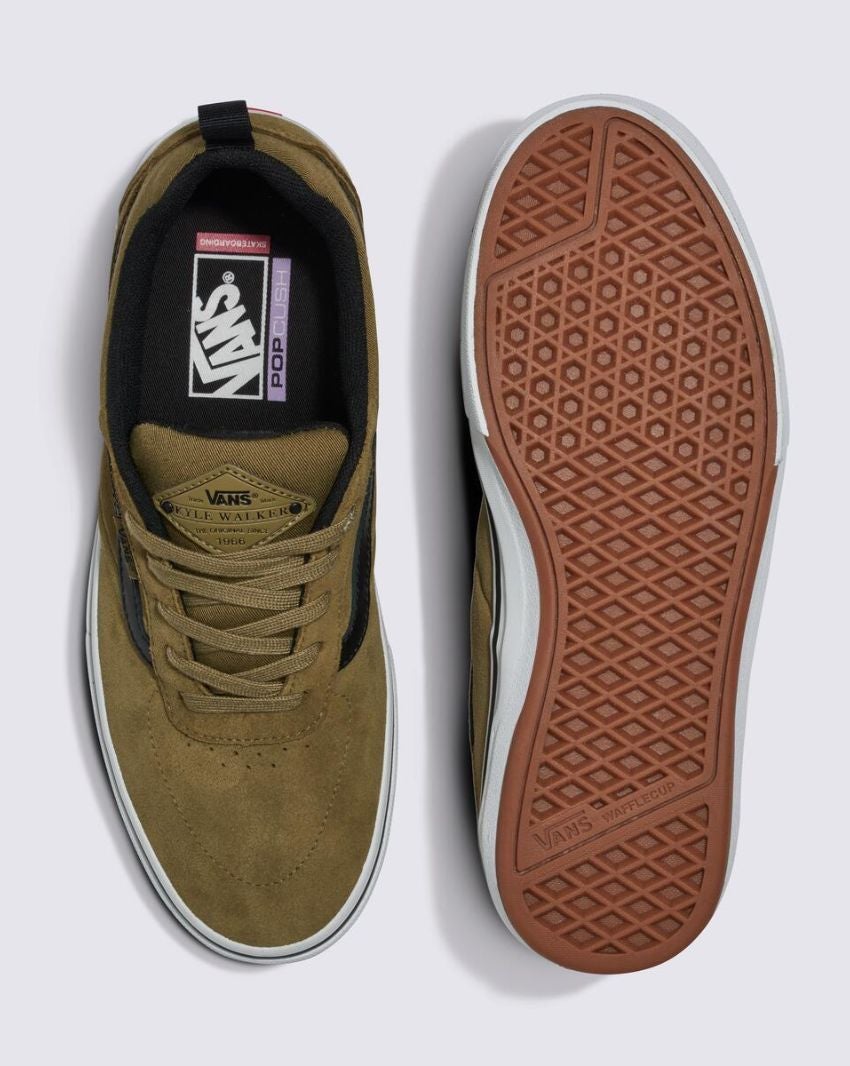 A pair of Vans Pro Skate Kyle Walker sneakers in Gothic Olive shown from the top and bottom views. The left shoe displays the insole branding, while the right shoe showcases the DURACAP™ reinforced tread pattern of the WAFFLECUP™ rubber sole.