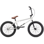 The Kink Gap XL 20 Inch Bike features a sleek white frame, accented with a brown seat, black handlebars, and large black tires. Its 21” top tube and durable Chromoly frame make it both stylish and sturdy against a plain background.