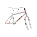 The Skyway TA 20 Replica Frame / Fork / Bars Kit is a white BMX frame set adorned with red and blue "Skyway" decals on the top, seat, and down tubes. Crafted from Chromoly tubing, this kit includes integrated forks and handlebars.